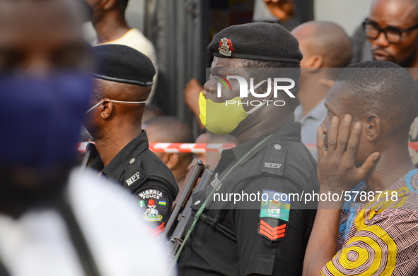 Police officers covering their nose with a mask securing the scene of the building collapse at Gafari Balogun street, Ogudu area of Lagos on...
