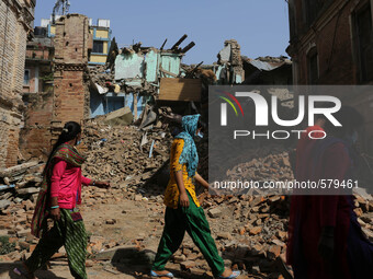 People are passing by the destroyed buildings. Sankhu, Nepal. May 3, 2015. (
