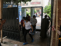 Students exit from the examination committee through sterilization gates during the first day of high school exams in Giza Governorate, Egyp...