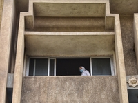 High school student wearing face mask look out of a window during the first day of the final exams, on June 21, 2020 in Cairo, Egypt. (