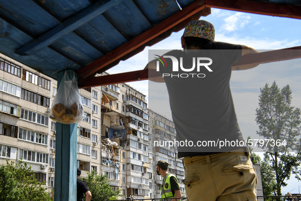 Locals watch Ukrainian rescue workers clean debris after a suspected gas explosion  in an apartment building in Kyiv, Ukraine, 21 June 2020....