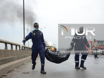 Men of Lagos State Emergency Management Agency carrying the remains of a burnt tanker truck driver following a gas explosion, involving four...