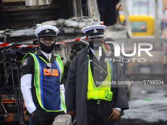 Men of Nigerian polices stand to control crowed off the scene following a gas explosion, involving four articulated vehicles on the Kara bri...
