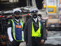 Men of Nigerian polices stand to control crowed off the scene following a gas explosion, involving four articulated vehicles on the Kara bri...