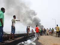 A man pointing to the explosion scene following a gas explosion, involving four articulated vehicles on the Kara bridge section of Lagos-Iba...