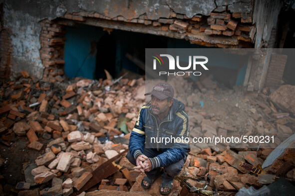 A man is sitting in front of his destroyed building. Sundhara, Kathmandu, Nepal. May 1, 2015. 