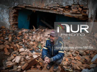 A man is sitting in front of his destroyed building. Sundhara, Kathmandu, Nepal. May 1, 2015. (
