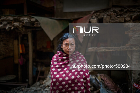Niru is standing in front of her destroyed house. Sundhara, Kathmandu, Nepal. May 1, 2015. 