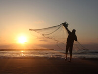 A Palestinian fisherman prepares his net before heading into the surf to cast it in search of fish on the beach in Gaza City on  May 10, 201...