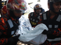 Rescuer workers carry body of a victim after a ferry capsized at Sadarghat Launch terminal in Dhaka, Bangladesh on June 29, 2020. At least 3...