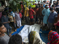 People standing beside dead bodies of victims who died in ferry capsize in the river Buriganga beside Sadargrat port at Dhaka, Bangladesh on...