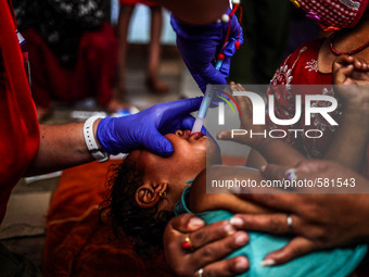 An Israel medical team member is giving medicine to a child victim of earthquake, Bhaktapur, Nepal May 9 2015. (