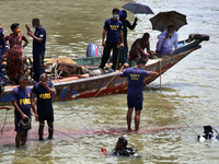 Firefighters and other rescuers are trying to lift sunken launch Morning Bird in river Buriganga, Dhaka, Bangladesh on June 30, 2020. (