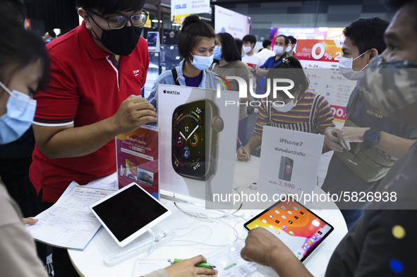 Visitors wear protective facemasks inspect iPhones at the Thailand Mobile Expo 2020 in Bangkok, Thailand, 04 July 2020. 