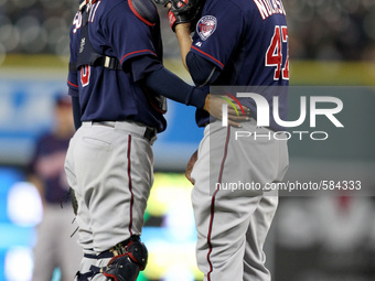 Minnesota Twins starter Ricky Nolasco talk to catcher Kurt Suzuki during the sixth inning of a baseball game against the Detroit Tigers in D...