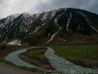 ZOJILA, INDIAN ADMINISTERED KASHMIR, INDIA - MAY 13: River Sindh flows next to the snow-cleared Srinagar-Leh highway on a treacherous pass...