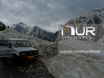 ZOJILA, INDIAN ADMINISTERED KASHMIR, INDIA - MAY 13: A Kashmiri driver parks his vehicle on the snow-cleared Srinagar-Leh highway on a treac...