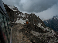 ZOJILA, INDIAN ADMINISTERED KASHMIR, INDIA - MAY 13: A vehicle passes through the snow-cleared Srinagar-Leh highway on a treacherous pass  a...
