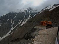 ZOJILA, INDIAN ADMINISTERED KASHMIR, INDIA - MAY 13: A vehicle passes through the snow-cleared Srinagar-Leh highway on a treacherous pass  a...