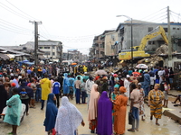  Hundreds of people gather at the scene of a three-story building collapse barricade by the police, where three persons have been confirmed...