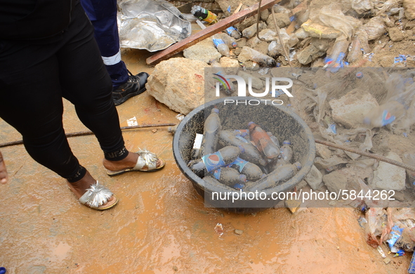 Occupants of the residents rescue the remains of their belongings among the ruins of a collapsed building, where three persons have been con...