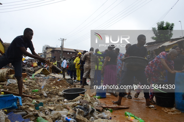 Occupants of the residents rescue some remains of their belongings among the ruins of a collapsed building, where three persons have been co...