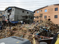 Men of Lagos State Emergency Management Agency sill off the remains of the collapsed building, where three persons have been confirmed died...