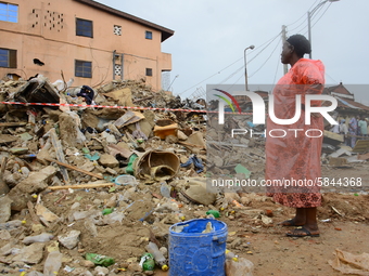 An elderly woman look on at the remains of the collapsed building, where three persons have been confirmed died and nine injured following a...