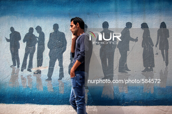 A Palestinian man talking on the phone in front of a mural related to journalistsin Gaza city on May 14, 2015. 