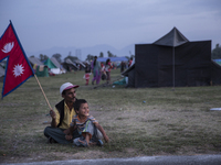 KHATMANDU, NEPAL-- May 14, 2015- Father and son holding a Nepali flag at a camp in Kathmandu for people displaced by the recent earthquakes....
