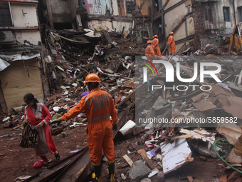 Rescue workers work at the site after portion of a building collapsed in Mumbai, India on July 17, 2020. Six people were killed and 15 rescu...