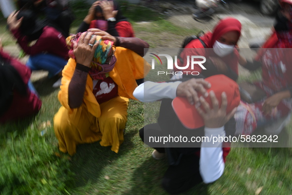 Residents simulate or practice how to protect themselves in the event of an earthquake and tsunami in Wani Village, Donggala Regency, Centra...