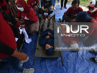 
Residents simulate or practice how to treat injured victims in the event of an earthquake and tsunami in Wani Village, Donggala Regency, C...