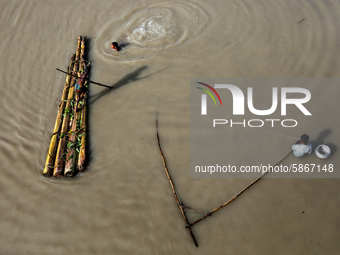 Children are seen on an improvised makeshift raft on a flooded area in Jamalpur, Bangladesh, on July 20, 2020.  (