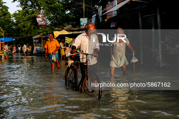 People walk on a flooded road in Jamalpur, Bangladesh, on July 20, 2020.  