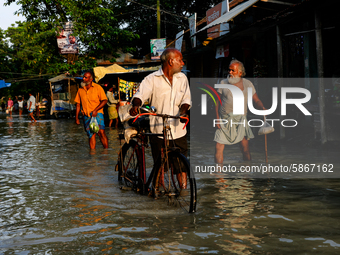 People walk on a flooded road in Jamalpur, Bangladesh, on July 20, 2020.  (