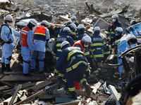 March 18, 2011-Rikuzen Takata, Japan-Rescue Team exhumation burial body at Debris and Mud covered on Tsunami hit Destroyed city in Rikuzenta...