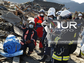 March 18, 2011-Rikuzen Takata, Japan-Rescue man marking exhume body information at Debris and Mud covered on Tsunami hit Destroyed city in R...