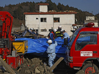 March 18, 2011-Rikuzen Takata, Japan-Rescue Team searching burial person at Debris and Mud covered on Tsunami hit Destroyed city in Rikuzent...