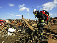 March 18, 2011-Rikuzen Takata, Japan-Rescue Team searching operation on debris and mud covered at Tsunami hit Destroyed city in Rikuzentakat...