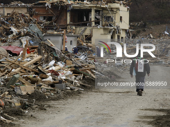 March 20, 2011-Rikuzen Takata, Japan-Native Survivors find their house lot on debris and mud covered at Tsunami hit Destroyed city in Rikuze...