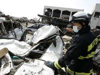 March 20, 2011-Rikuzen Takata, Japan-Rescue Team searching exhume body on debris and mud covered at Tsunami hit Destroyed city in Rikuzentak...
