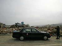 March 20, 2011-Rikuzen Takata, Japan-Taxi Driver take picture to hazard area on debris and mud covered at Tsunami hit Destroyed city in Riku...