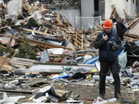 March 21, 2011-Ofunato, Japan-Polish Rescue team Searching burial body on debris and mud covered at Tsunami hit Destroyed Industrial Area in...