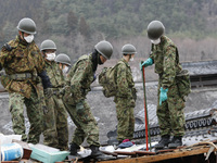 March 21, 2011-Ofunato, Japan-Military Searching burial body on debris and mud covered at Tsunami hit Destroyed Industrial Area in Ofunato o...