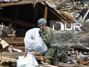 March 21, 2011-Ofunato, Japan-Military Searching burial body on debris and mud covered at Tsunami hit Destroyed Industrial Area in Ofunato o...