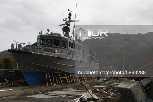 March 25, 2011-Kamaishi, Japan-Navy battleship strand near dock on debris and mud covered at Tsunami hit Destroyed mine town in Kamaishi on...