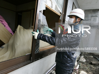 March 25, 2011-Kamaishi, Japan-Native survivors repair with clean up their house  on debris and mud covered at Tsunami hit Destroyed mine to...