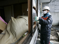 March 25, 2011-Kamaishi, Japan-Native survivor repair with clean up their house  on debris and mud covered at Tsunami hit Destroyed mine tow...