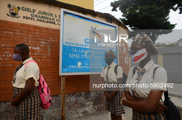 High school students wear face masks as they wait outside the entrance of Girls Junior Grammar School, S.W, Ikoyi, Lagos on August 3, 2020 o...